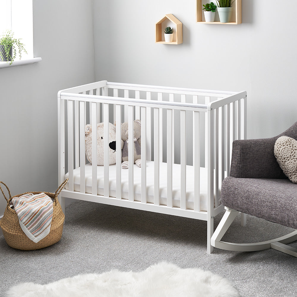 Compact cot with rails on all 4 sides with teething rails. 