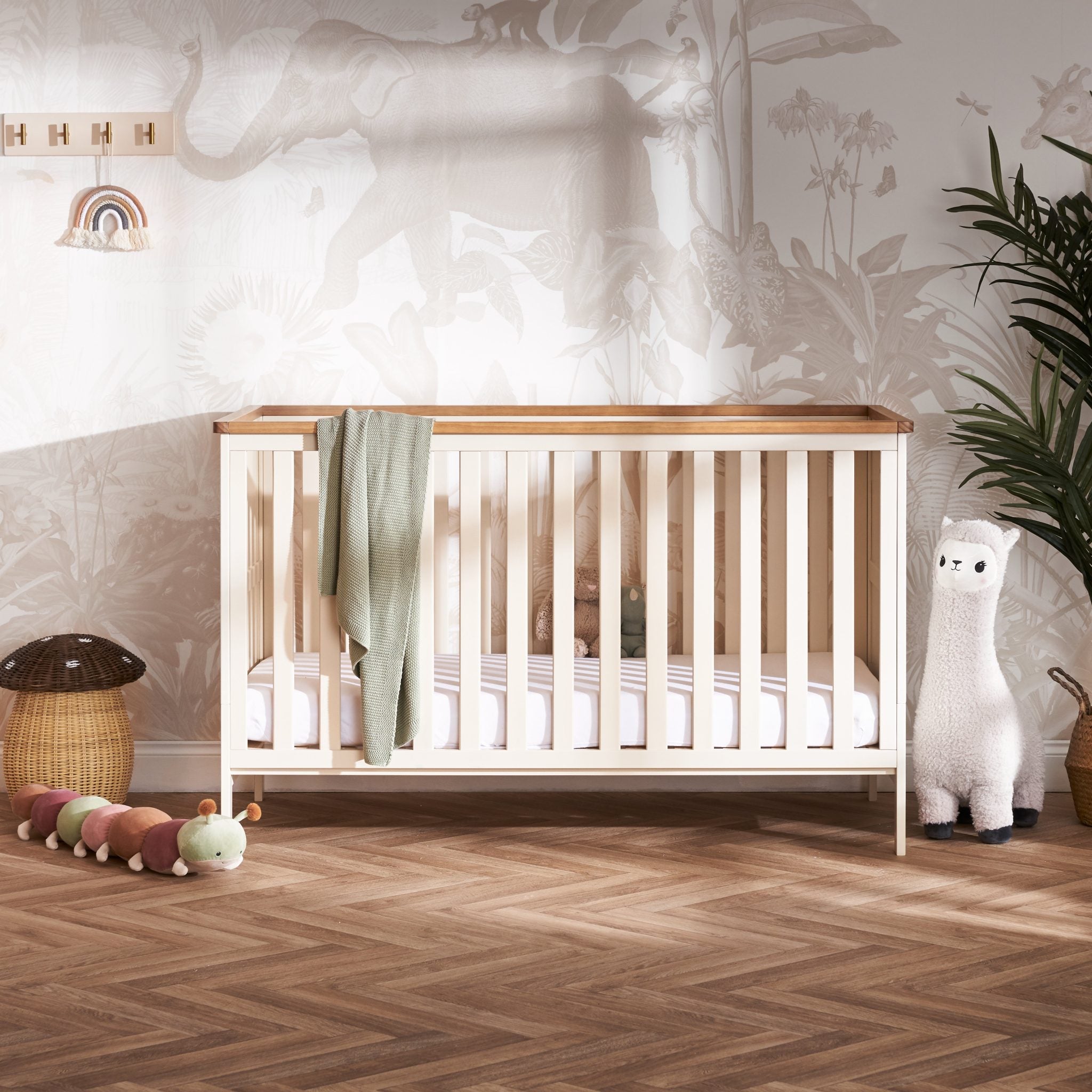 Cot bed with solid ends, wooden trim on top. Base on the lowest setting.