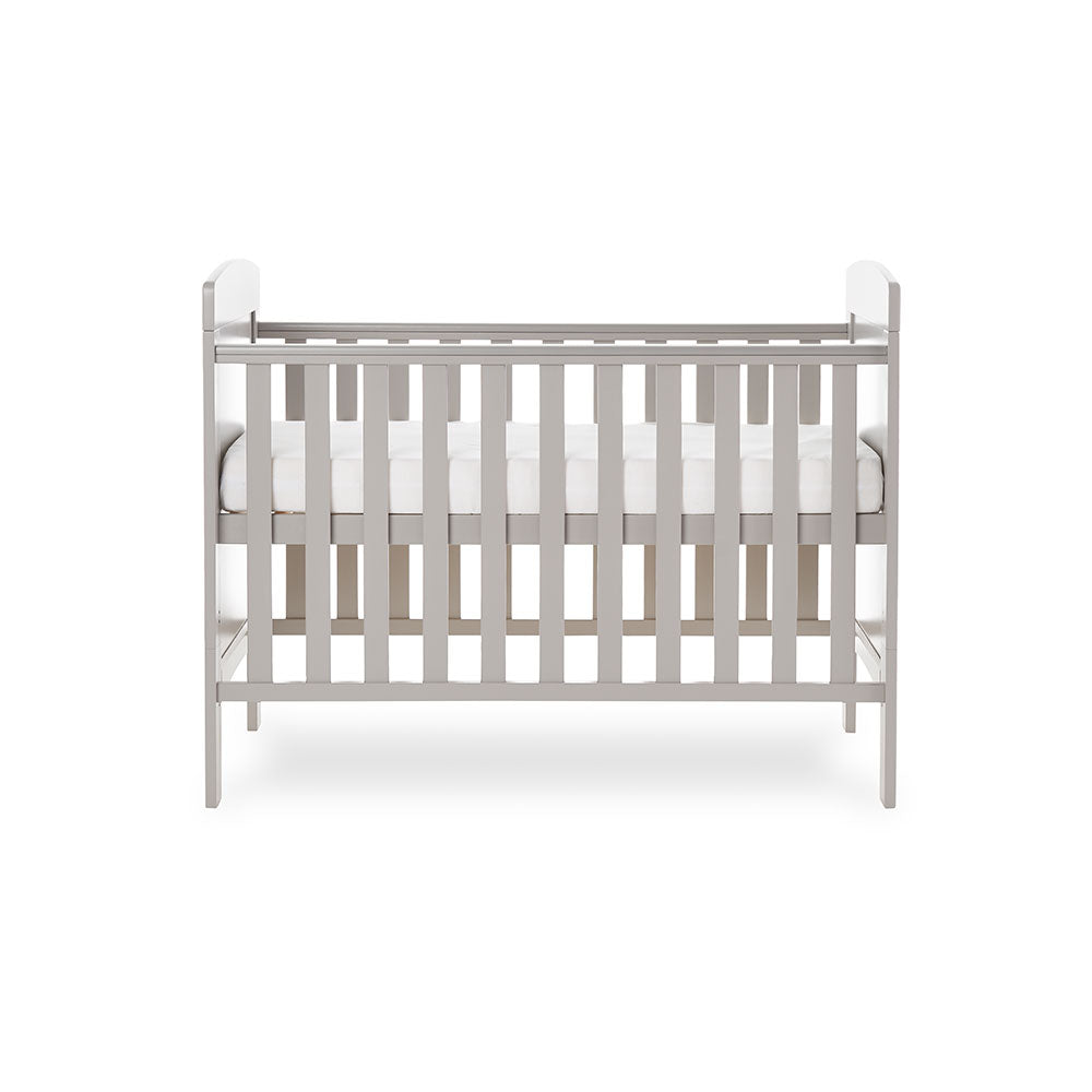 Mini cot bed with solid ends, curved top & teething rail fitted on rails. base on the new born setting